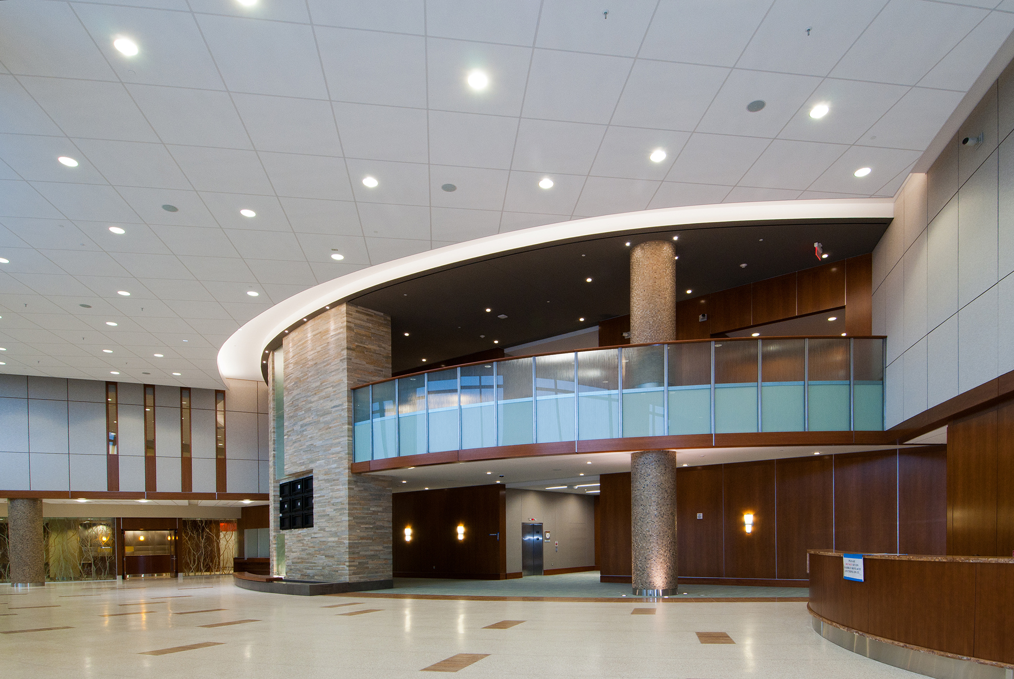 A large lobby with a circular staircase and glass walls.
