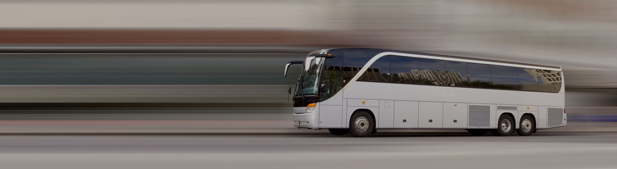 A white bus driving down the street with its doors open.
