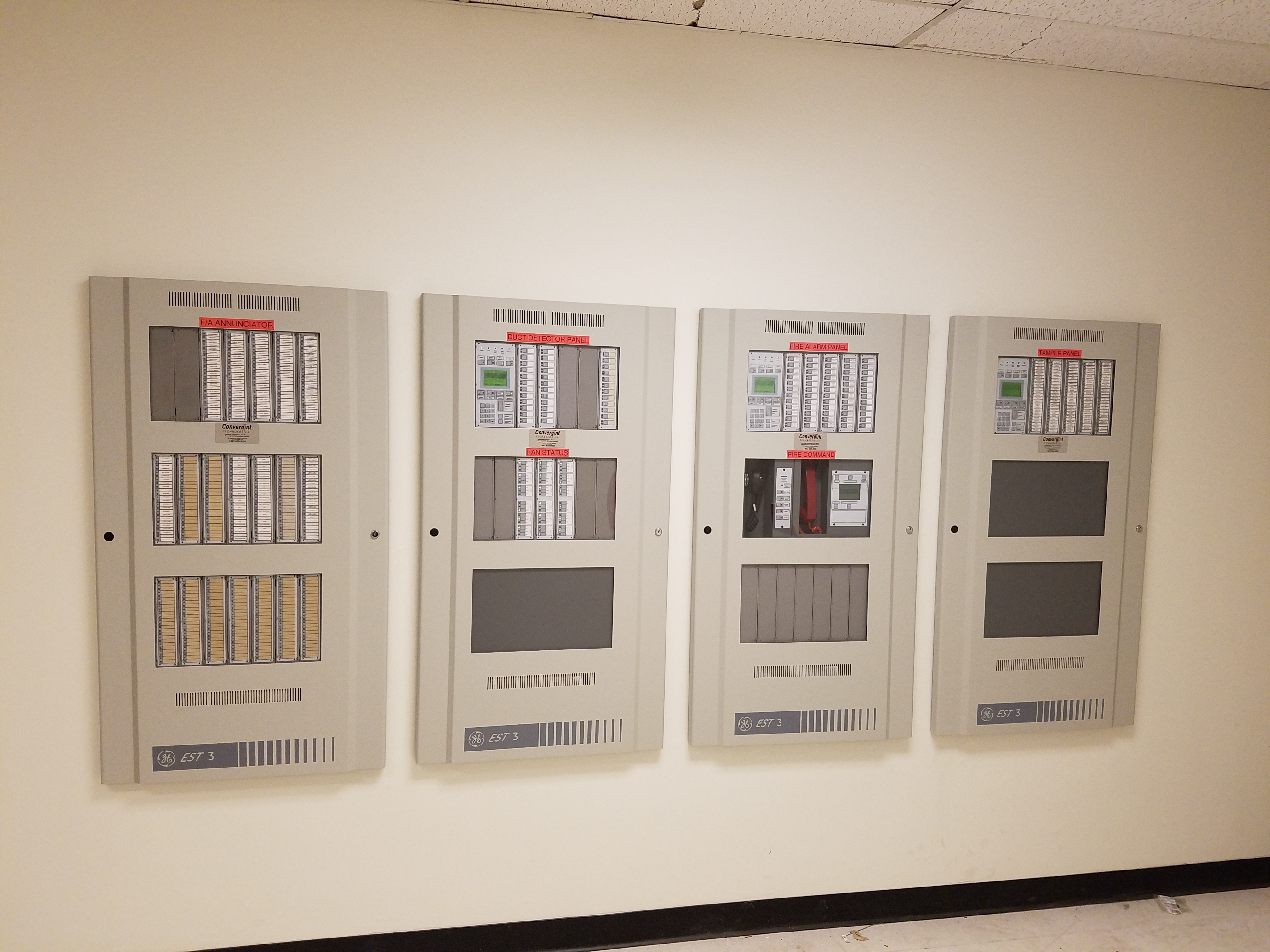 A wall with four different types of electrical boxes.