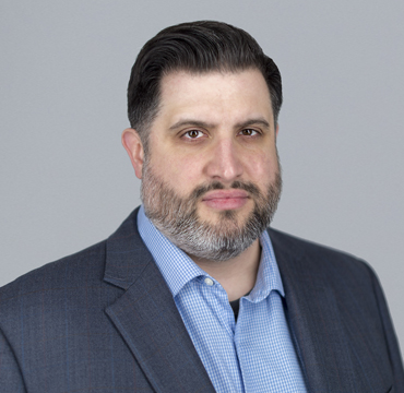 A man with a beard and suit jacket