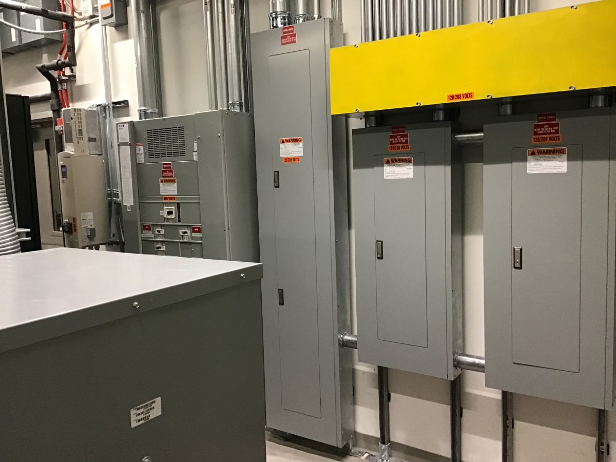 A room with many electrical boxes and wires.